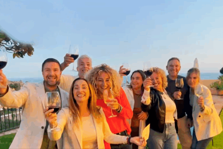 Fotografía de un grupo de personas sonriendo, con una copa de vino en la mano.