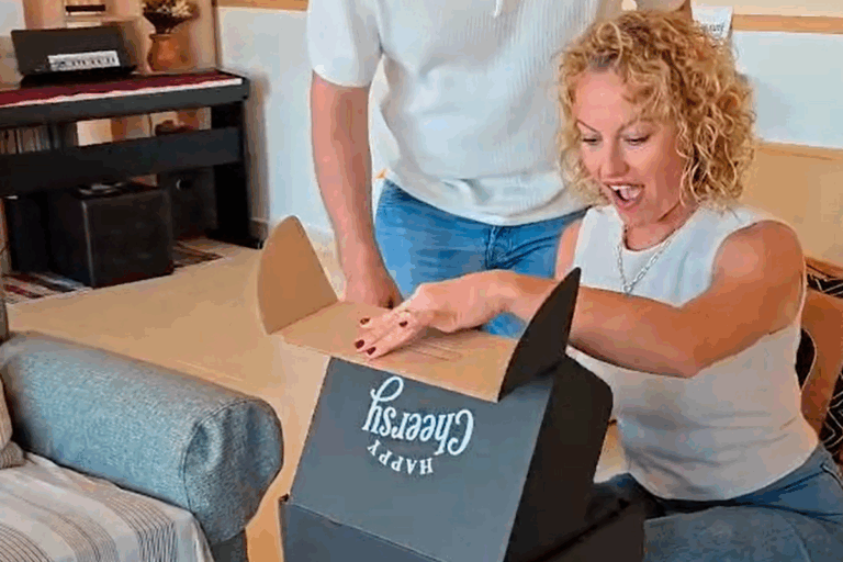 Fotografía de una mujer sorprendida abriendo un paquete de Happy Cheersy.
